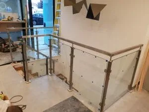 Glass balustrade with square stainless steel posts on a landing